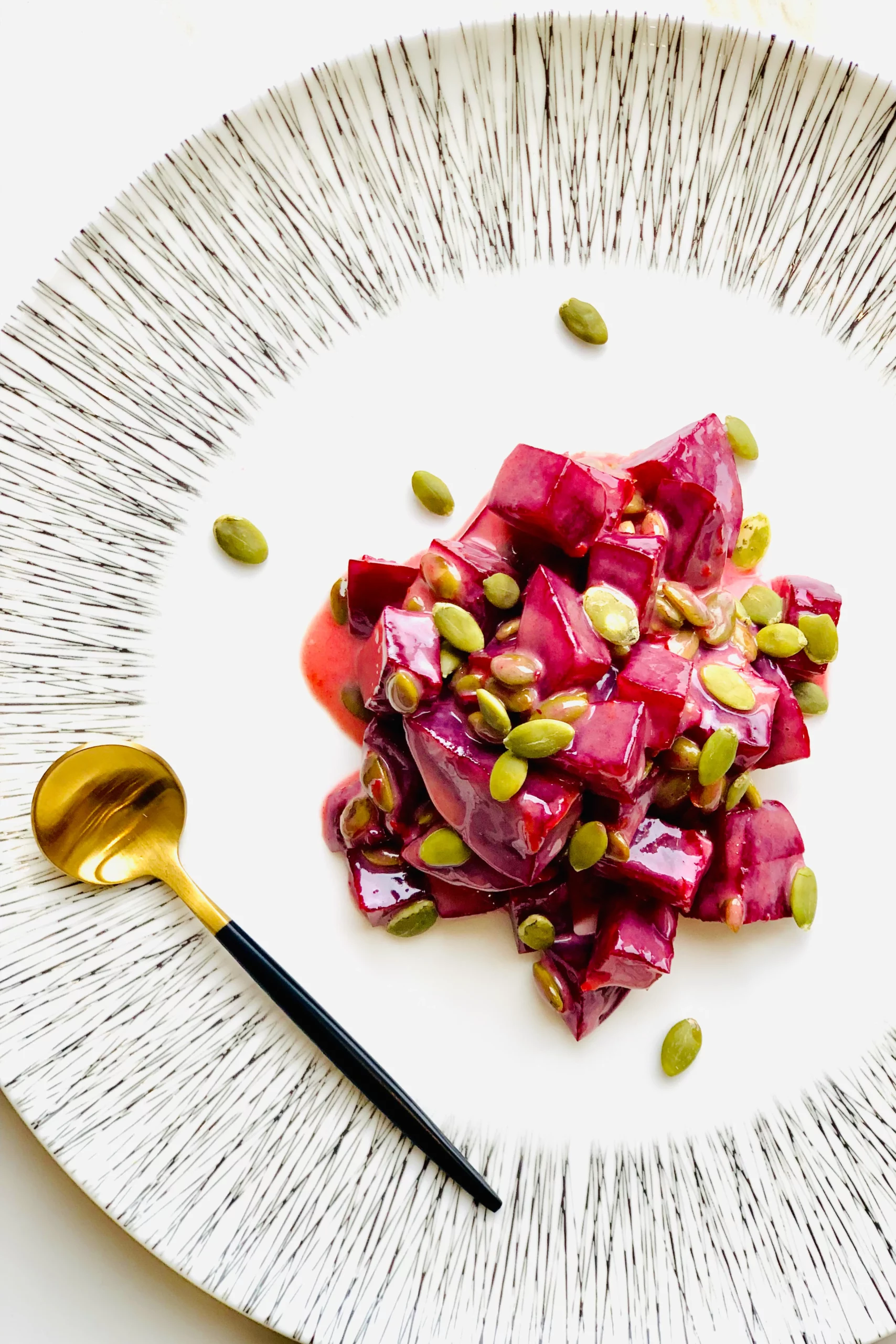 image of beets plated with a gold spoon